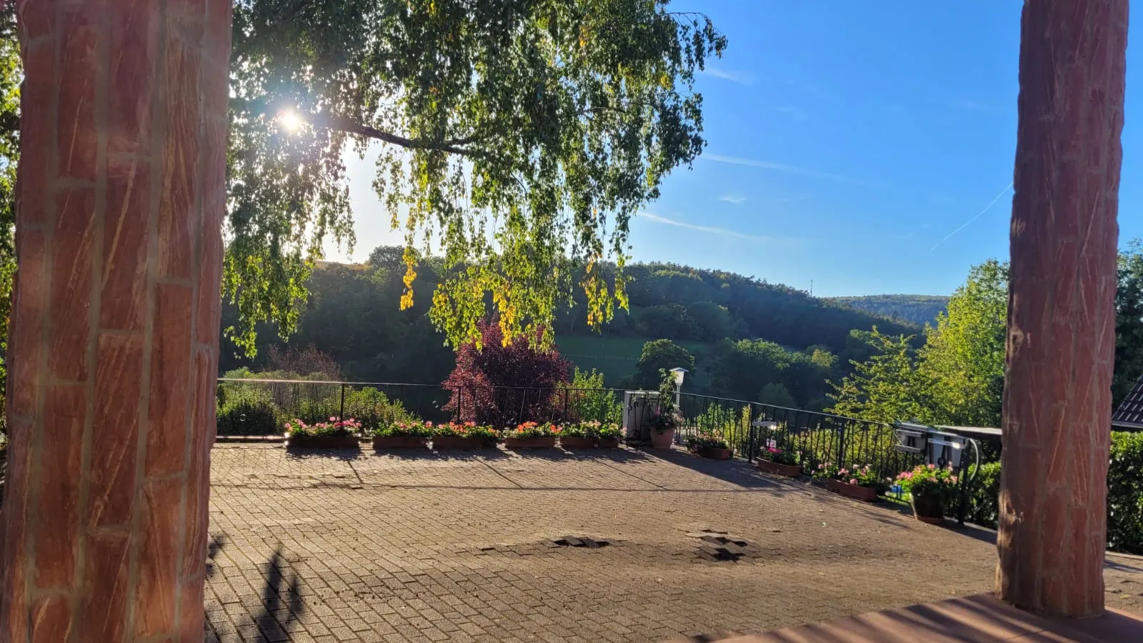 Sonnige Terrasse des Tagungshauses in Lützelbach mit Blick auf die bewaldeten Hügel des Odenwalds.